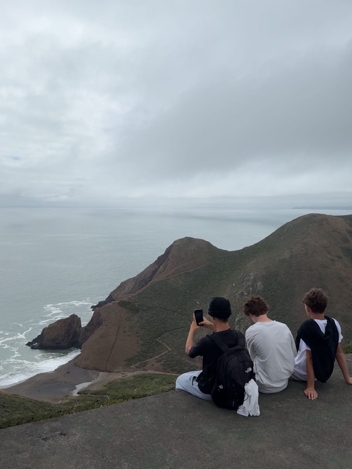 Ben Nisevich with friends on a headland above the Pacific coast